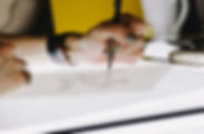 A woman's hand designing a company logo on a piece of paper