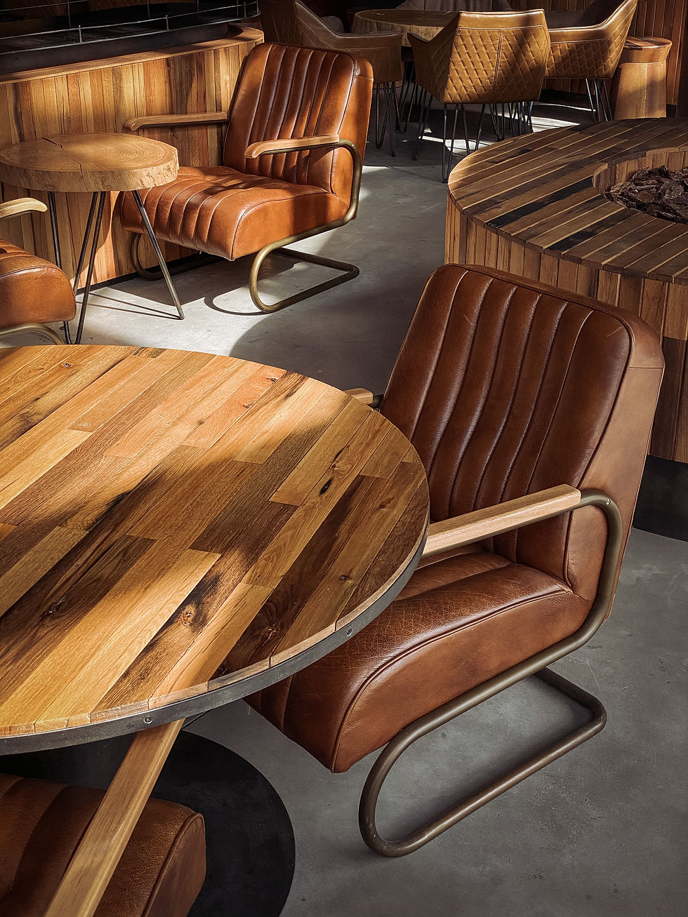 Cozy and stylish, this seating area features plush, leather chairs complemented by rich wooden tables, creating a warm and inviting atmosphere perfect for relaxation or intimate gatherings.
