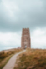 Glastonbury Tor with a moody sky in the background.