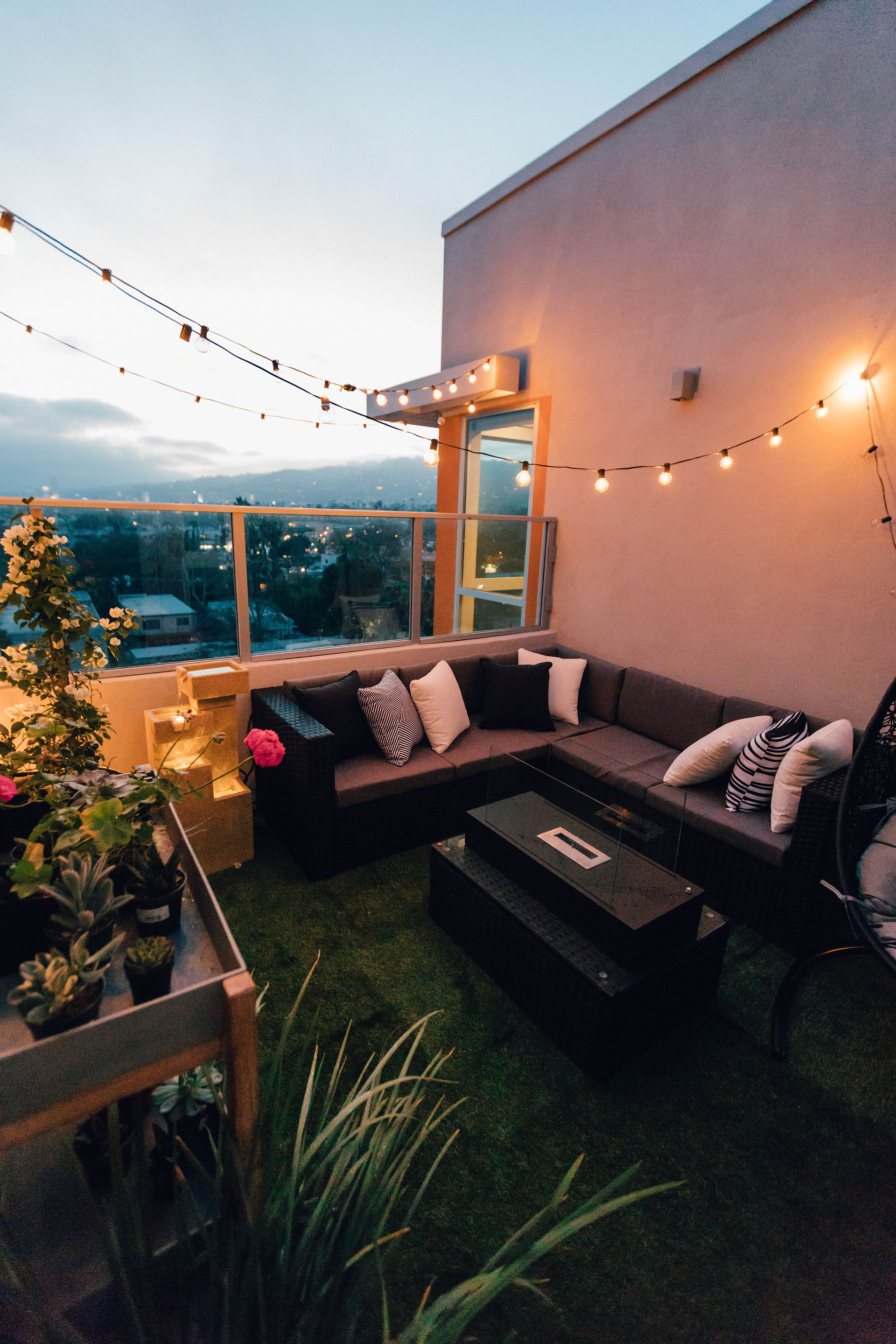 The roof terrace includes a sofa, lighting and a table, creating a convivial atmosphere and a welcoming outdoor space.