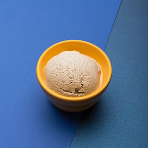 Minnesota branded Kemp's ice cream in a yellow bowl on a blue table