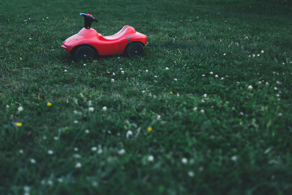 A child's scooter sits empty on the lawn.