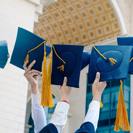 Students holding graduation caps.
