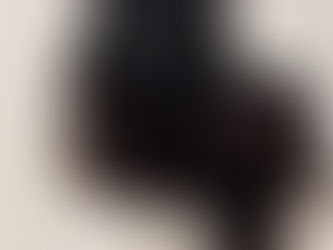 A black cat sitting on a white cat tree.