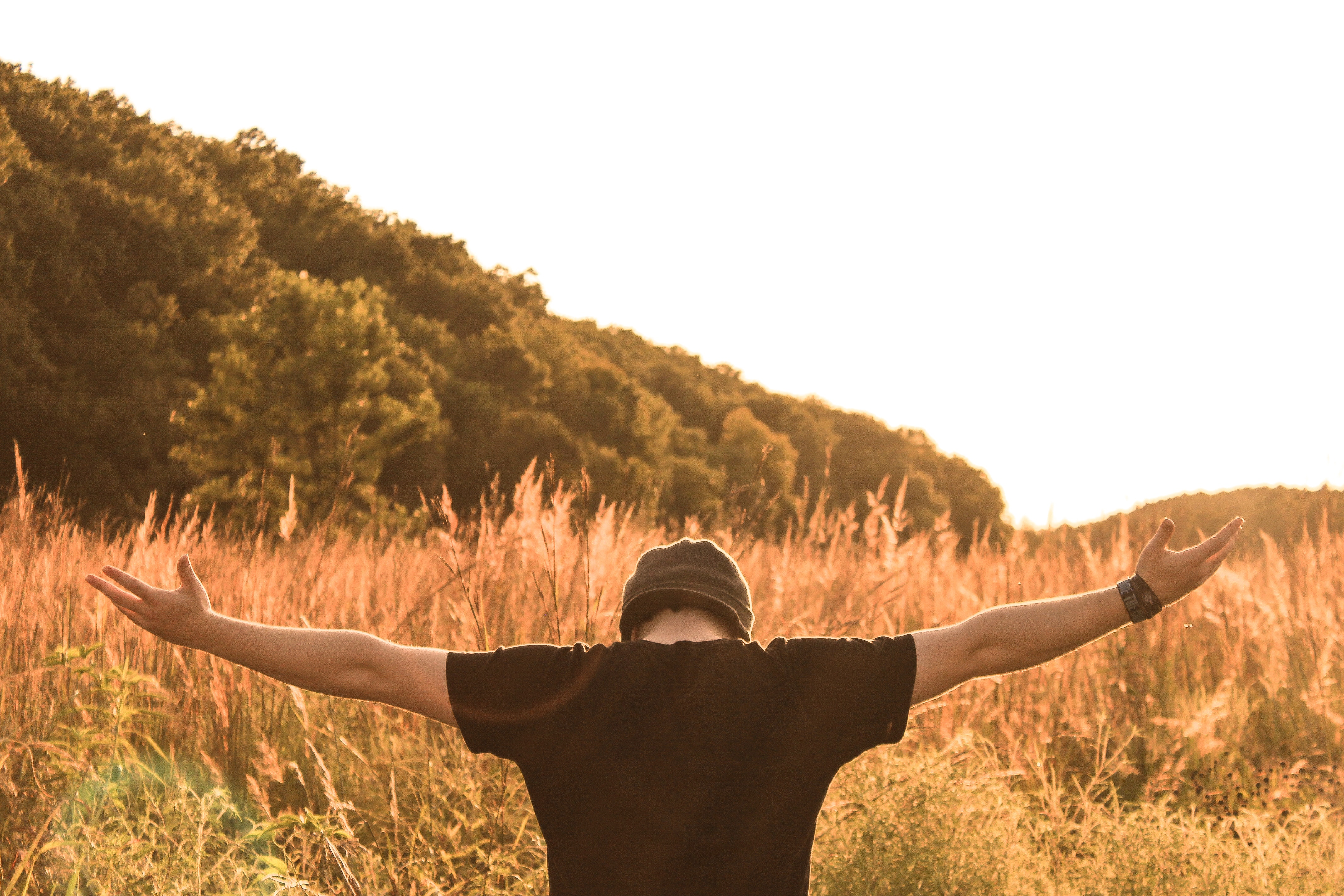 A person in a worshipful pose in nature