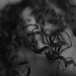 Mulher lavando o cabelo com shampoo sólido natural e vegano.