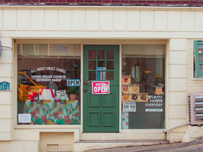 Local Storefront with Yes We're Open Sign on Door