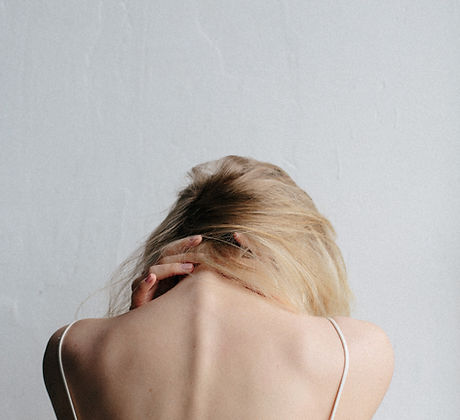 Blonde woman holding her neck in pain