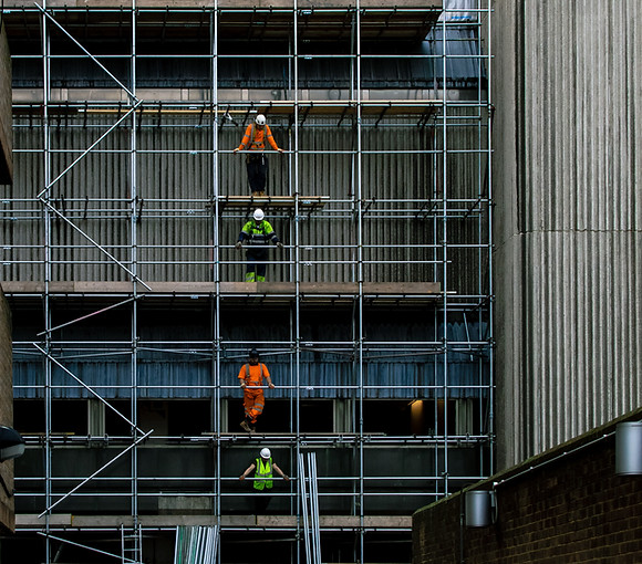 Borack Law Group offers services in Constriction Law law. Two men stand on different levels of scaffolding on a building.