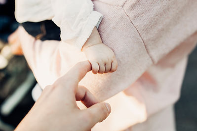 un bébé tient le doigt d'un adulte