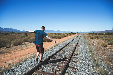 man walking on railroad tracks