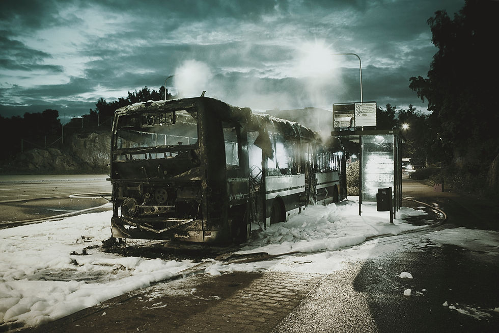 A burnt bus at a bus stop
