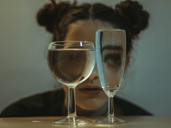 Woman's face seen through two glasses of water