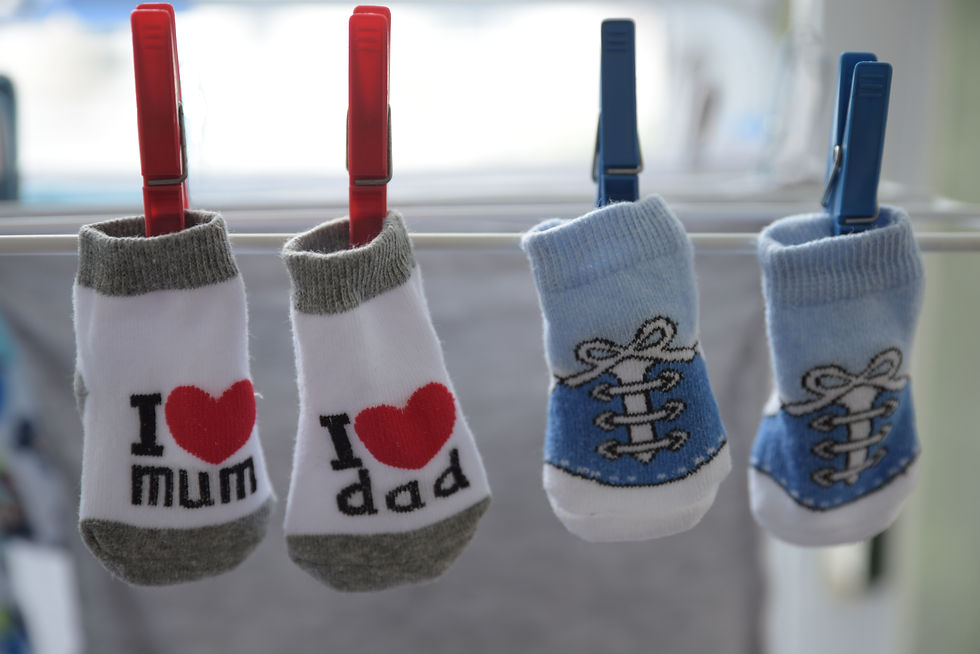Two pairs of baby socks: one that says "I love mum" "I love dad" and the other pair looks like a blue shoe with laces