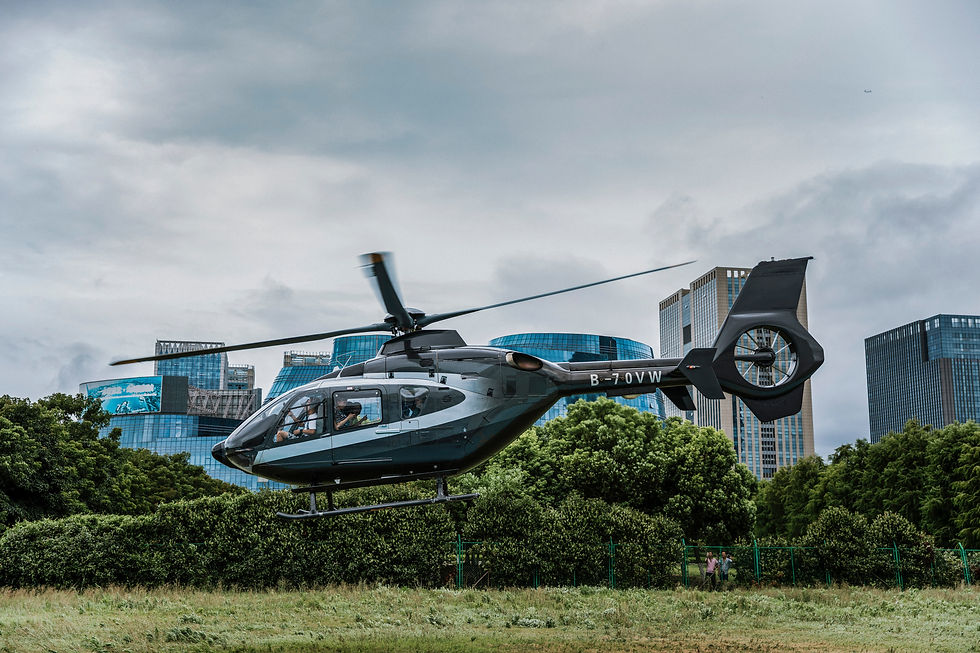 Helicóptero decolando em meio a uma área verde e prédios.