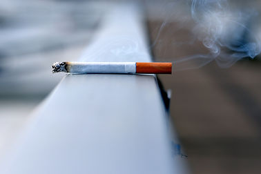 Lit cigarette resting precariously on a ledge