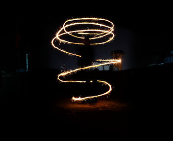 Image of a silhouette of a person with lights spiralling around them.