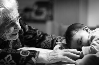 An elderly person with a baby