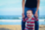 toddler on the beach with dad