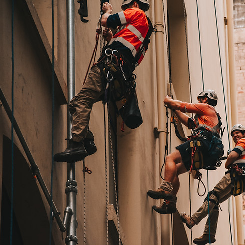 Rescue in safety gear and helmets perform rescue on a building