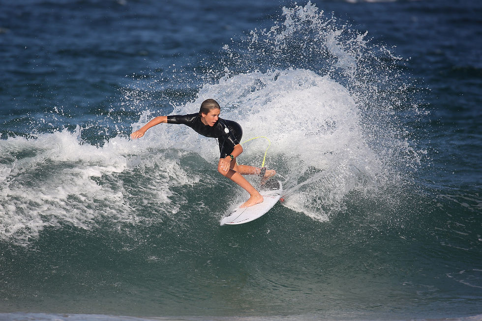 boy ripping a wave on his short board