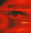 An eye and part of a face covered in red