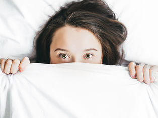women hides under a blanket