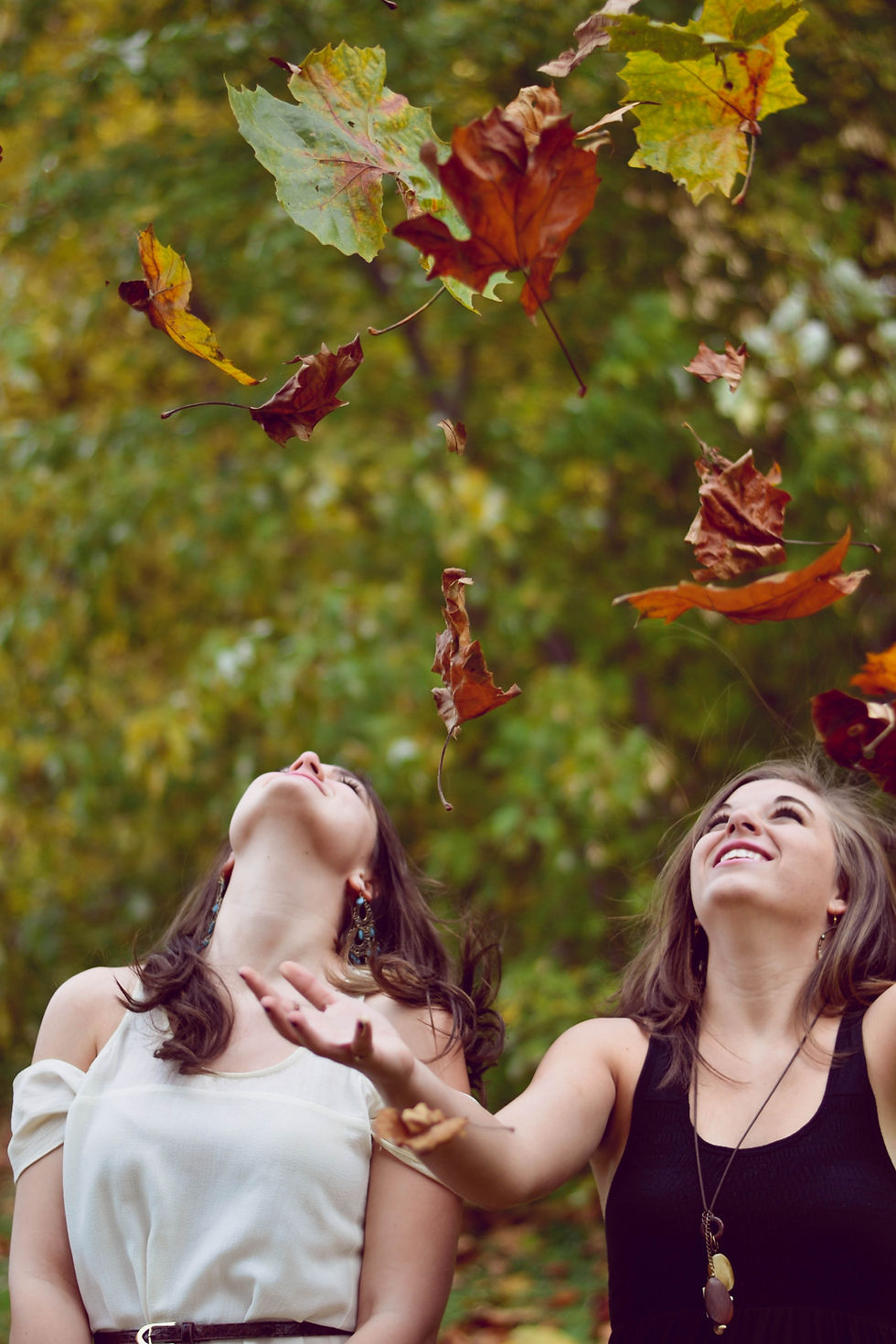 Girls playing in falling leaves