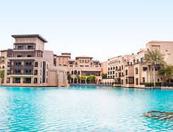 A luxury looking building/resort surroinds a blue pool