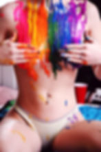 Girl with rainbow paint on her breasts