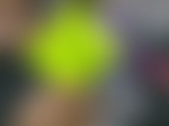 Person holding a bright green sticky note with "A.I." written on it in front of a blurred computer screen, conveying curiosity.
