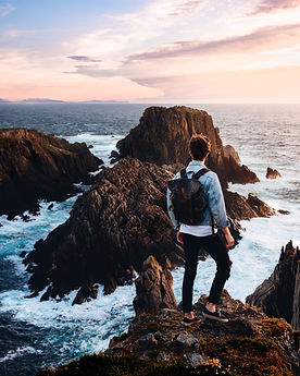 Man with backpack overlooking ocean vista