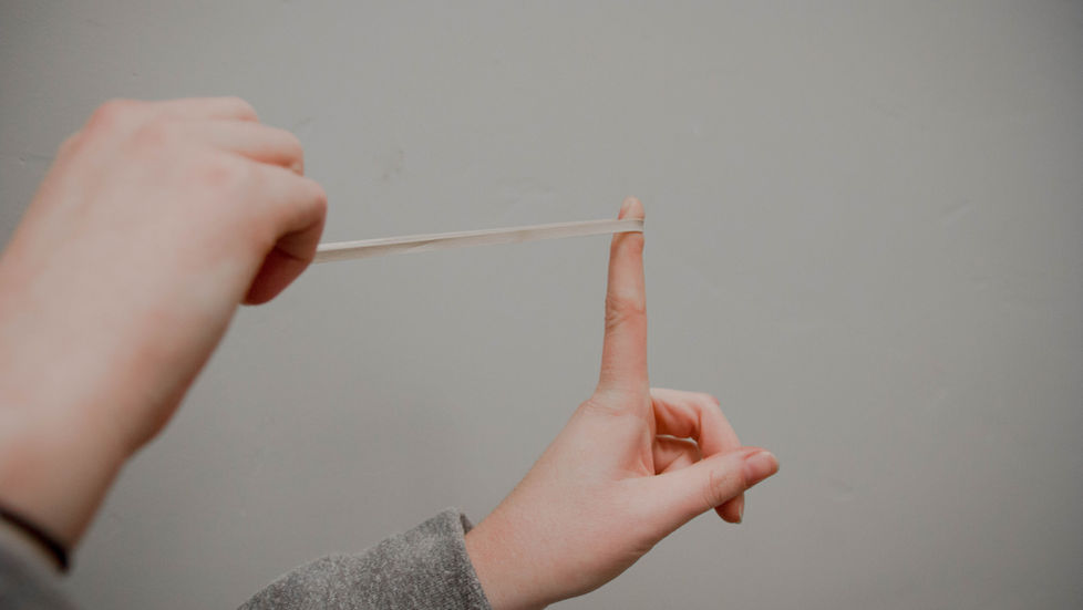 Des mains qui étirent un élastique