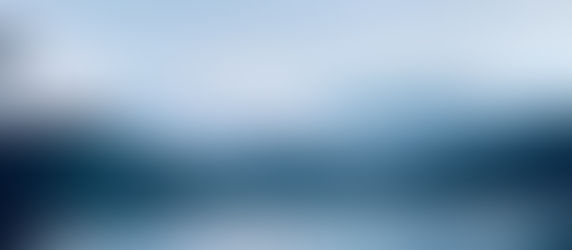 Cruise ship sailing into misty Alaskan fjords at sunrise