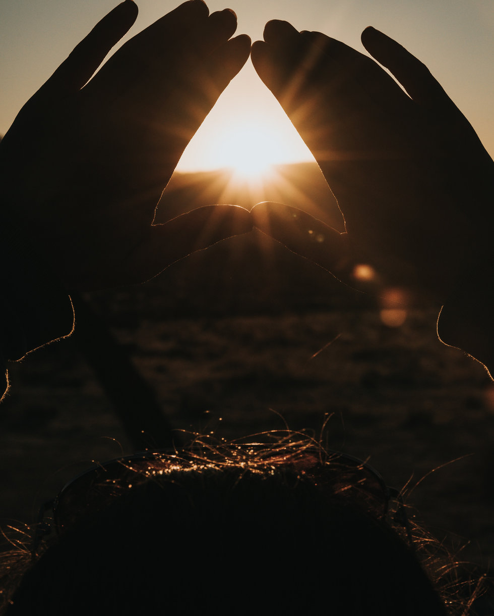 Sun setting behind a figure with glowing sparks in the foreground