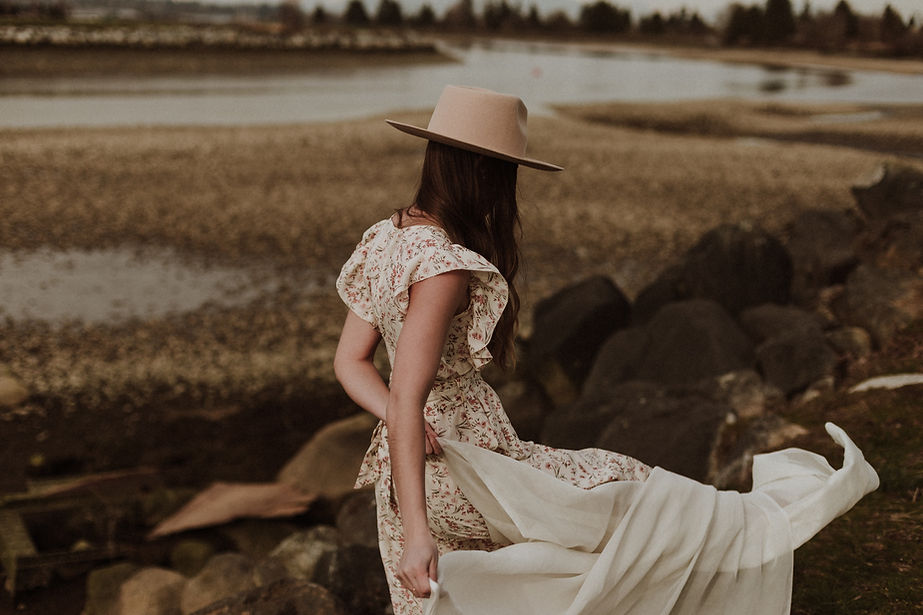 Beautiful woman walking on a coastline wearing a pink dress
