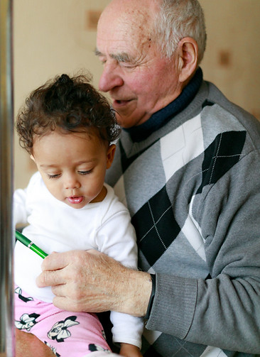 Elderly man reads to young child