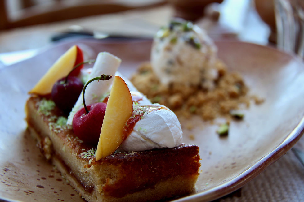 Photo Credit:
Nabih El Boustani
Dessert on a brown plate with sponge cake, whipped cream, cherries, and peach slices. Blurred background adds a cozy dining ambiance.