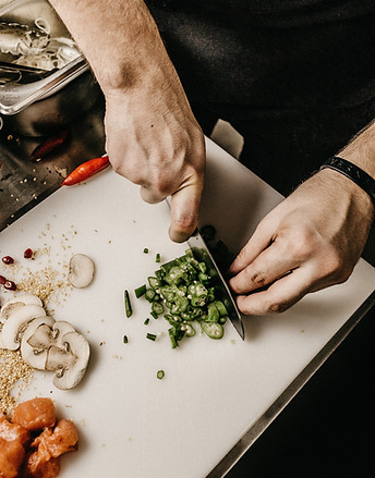 Chef preparing fresh vegetables for a catered dish.