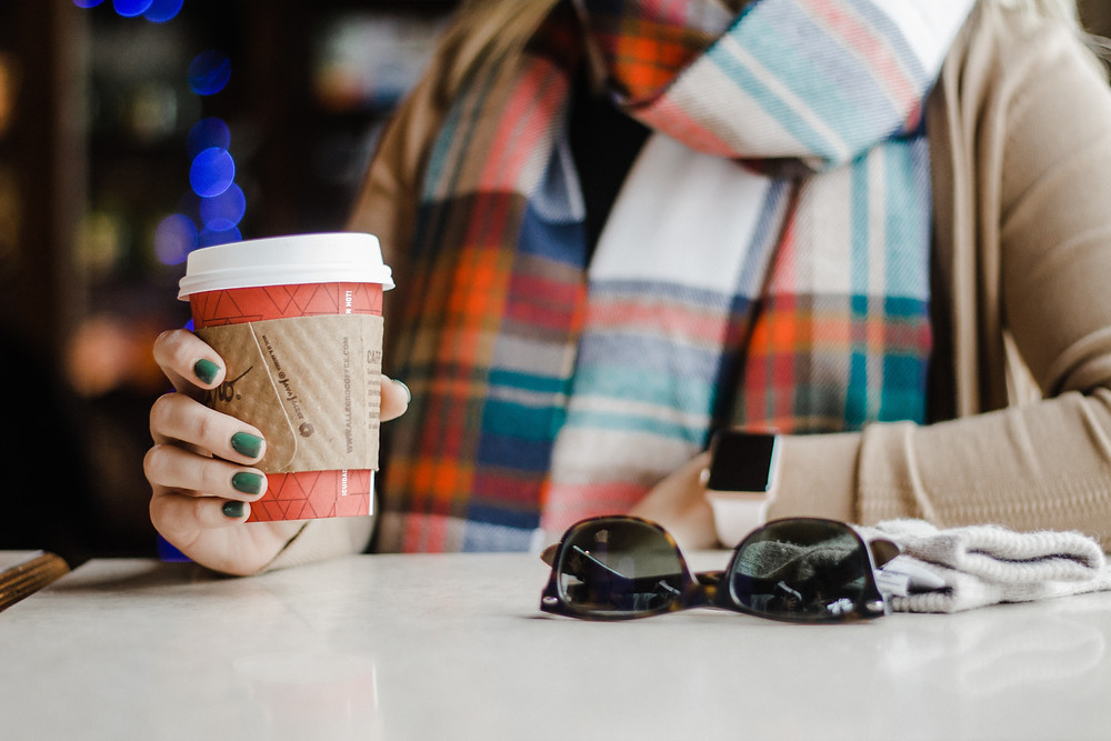 girl with green fingernails holding hot cup