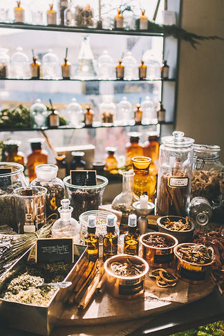bunch of different herbs inside jars, on top of shelves, and containers