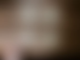 Hand placing a blank yellow sticky note on a wooden table with three other notes. Warm, natural lighting.