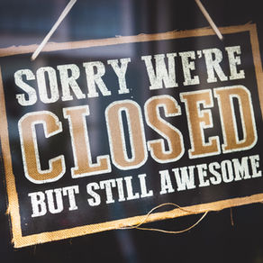 Closed sign hanging in store window