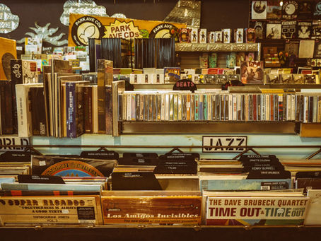 Shelves covered in records, cassettes, and CDs