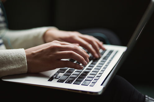 Hands typing on a laptop computer