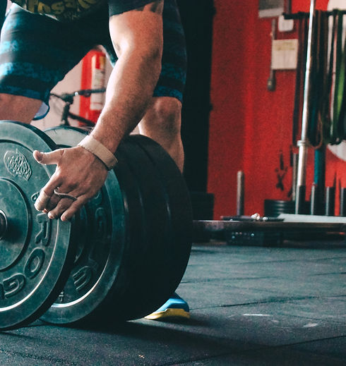 athlète chargeant la barre de musculation par le coach running