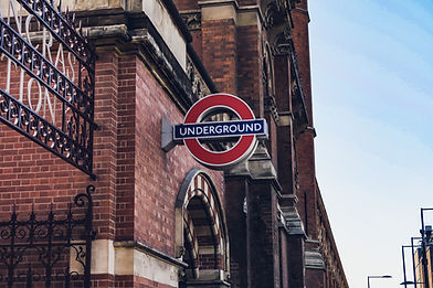 london underground sign on brick wall