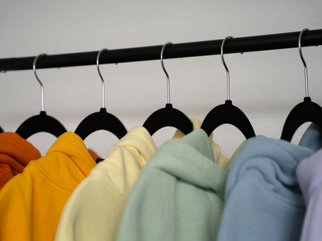 Askıda farklı renklerde toptan sweatshirt ve tişört modelleri – Bursa tekstil pazarında erkek ve kadın koleksiyonu.