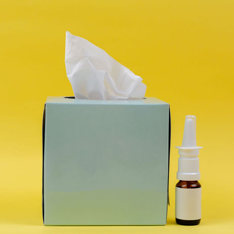 a bottle of xylitol nasal spray sits next to tissues for immune support