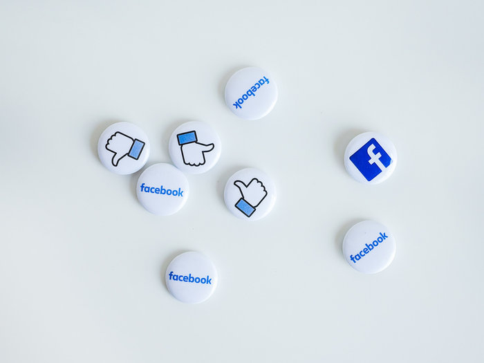 Social media badges scattered on a white surface